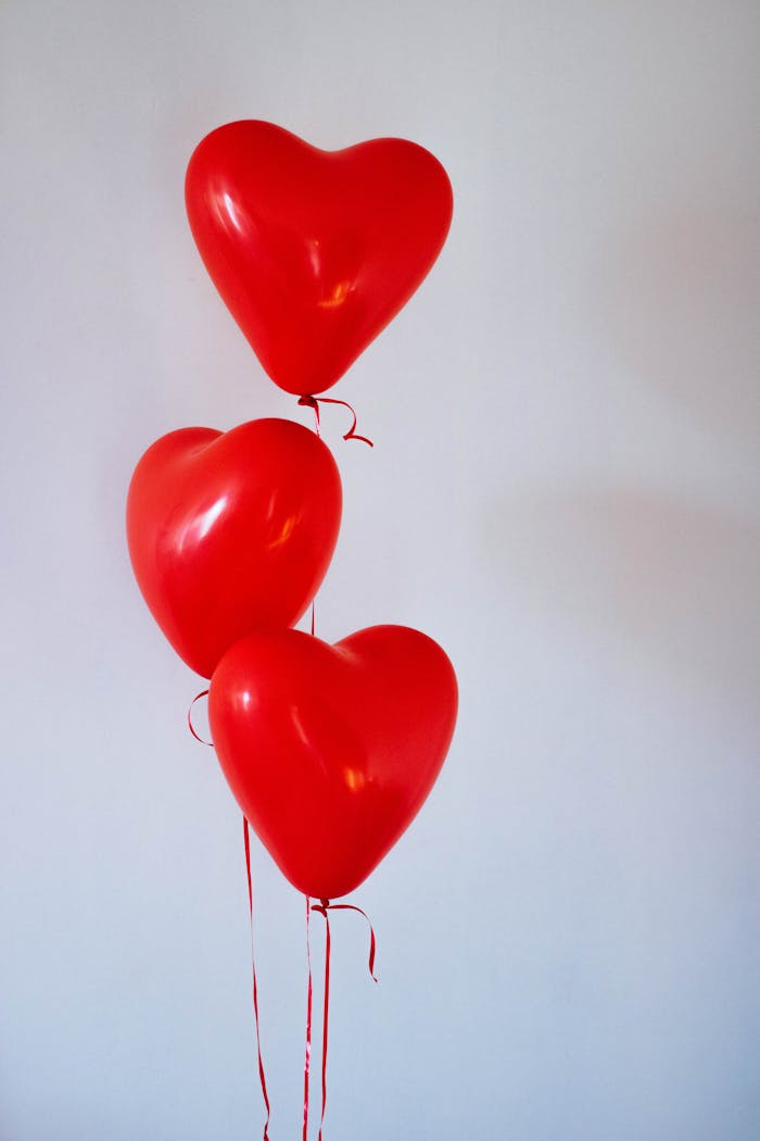 Mastering the First Impression: Your intriguing post title goes here Three red heart-shaped balloons floating in a minimalist studio setting, evoking love and romance.